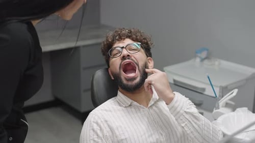 Man discusses dental health with woman at dentistry clinic during checkup appointment