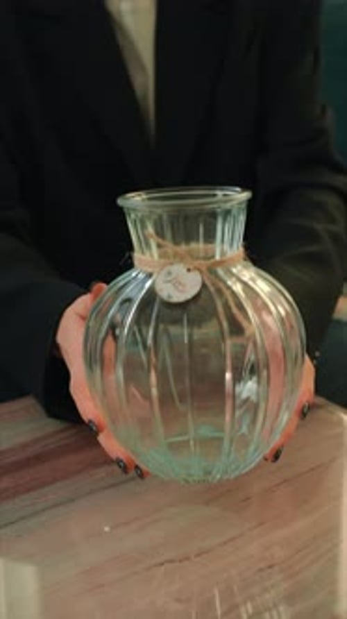 Vertical Person Holding Glass Vase on Table