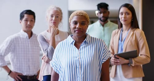 Smiling diverse business team standing together in modern office environment