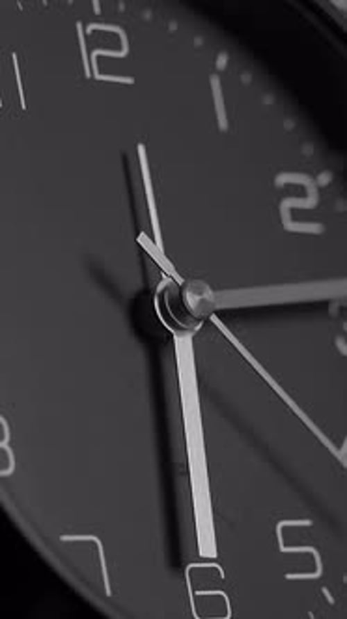 This is a Closeup View of a Classic Black Wall Clock Showcasing Its Elegant Design and Artistry