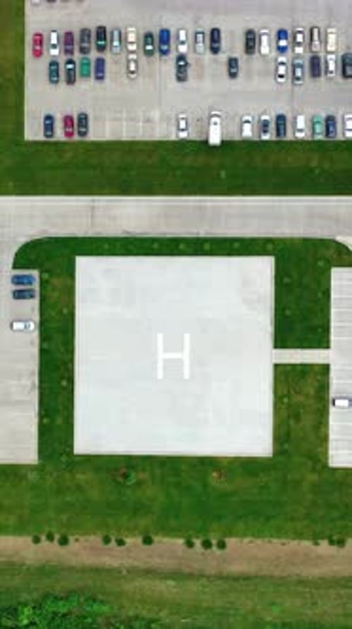 Car parking on a modern plant. Factory on green field with many cars on parking spaces.