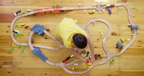 Child Playing with a Toy Train Set