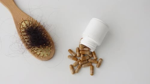 Hairbrush, Hair Loss, and Medicine on Table