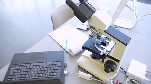 Microscope, Laptop, and Supplies on Desk