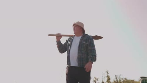 Farming Dedication Mature Man and His Trusty Shovel Side View and Tracking Shot