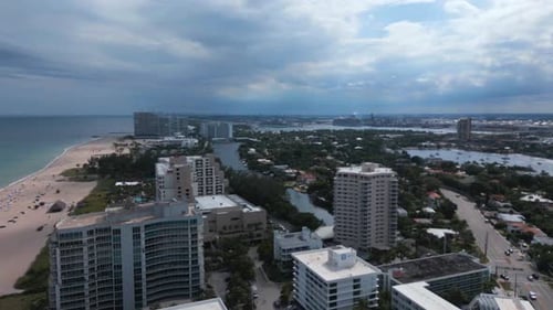 Aerial drone shot of hotel, settlement and villa beachside resort with dark sky