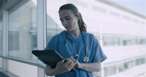 Portrait of Female Medical professional holding Digital tablet in Hospital and Looking at camera