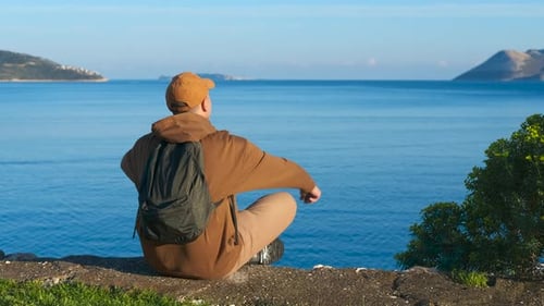 Tourist Raising Arms Enjoying Scenic Ocean View