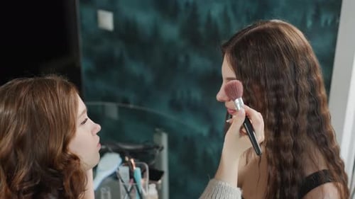 Woman Applies Makeup to Friend in Home