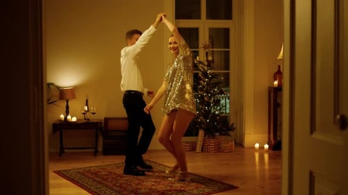 Sensual couple dancing christmas eve in party illumination at decorated apartment