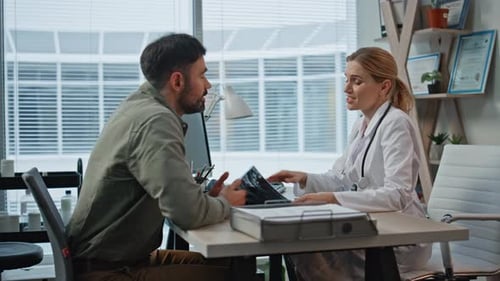 Medic Showing Xray Patient During Consultation in Clinic Smiling Doctor Talk