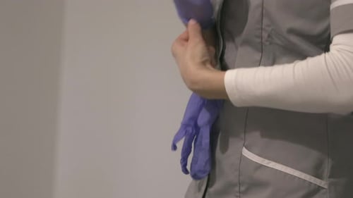 Cropped Portrait Of A Nurse Putting On Latex Gloves. closeup