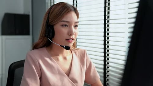 Kompetente Bedienerin, die am Computer arbeitet und mit Kunden spricht