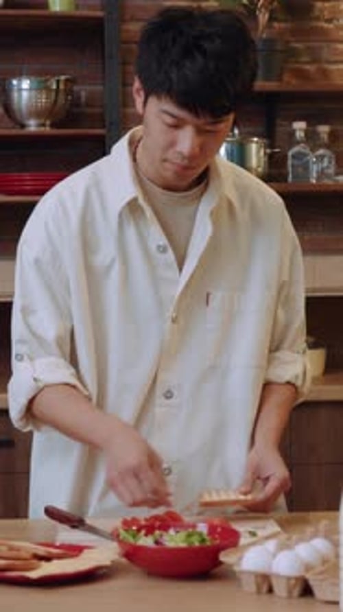 Young Adult Preparing a Dish in Kitchen