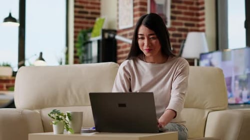 Smiling Woman Works on Laptop From Home