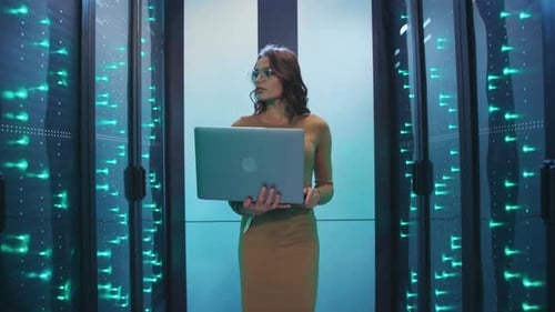 Woman Holds Laptop in Modern Server Room