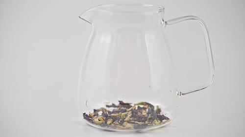 Pouring Water into Tea Kettle on White Table