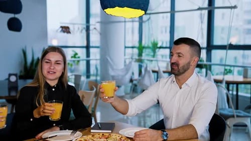 Friends Sharing Pizza Toasting Drinks at Restaurant