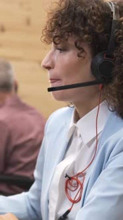 Woman at Computer Wearing Headset in Office