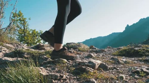 View on Feet of Traveler Woman Hiking Walking on the Top of Cliff in Mountain Walking on Rocks