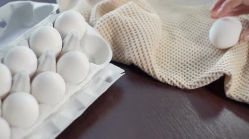 Fresh White Eggs Being Placed on Table