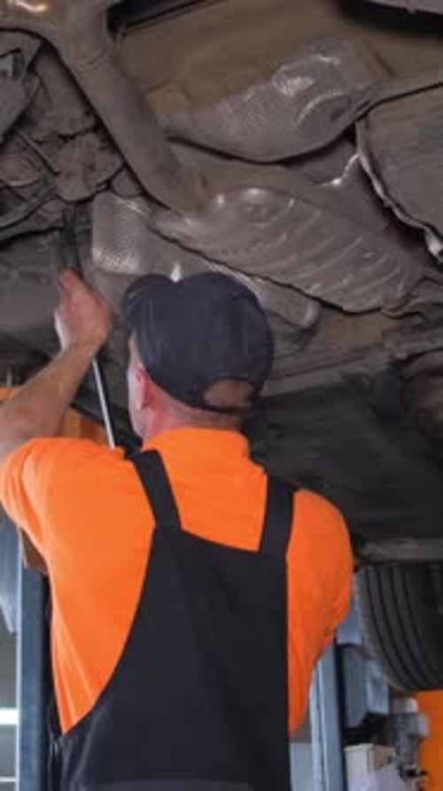A Mechanic Repairs the Chassis of a Car Car Workshop Vertical Video