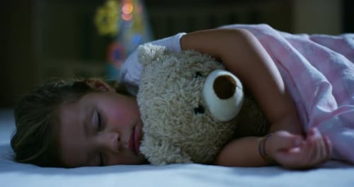 Girl Sleeping in Bed with Teddy Bear at Night
