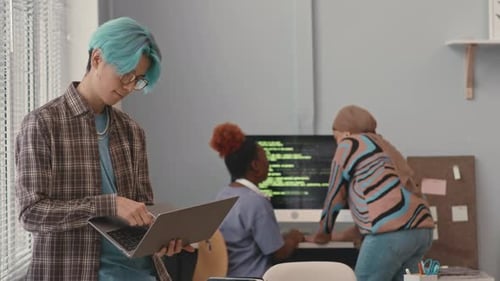 Jovem programador asiático usando laptop no escritório