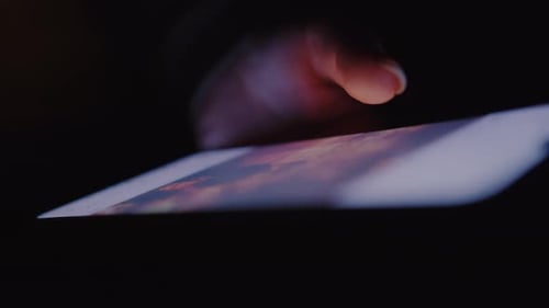 Close Up of Woman Hand Uses a Phone in the Dark Scrolling the Screen Glare Likes
