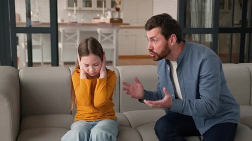 Father Arguing with Daughter on Couch at Home