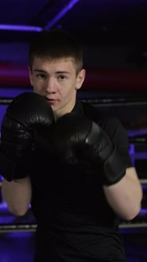 Young Male Boxer Training and Punching in a Boxing Ring