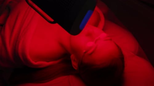 Closeup Top View of Female Client Having Red LED Light Facial Photodynamic Therapy Treatment in