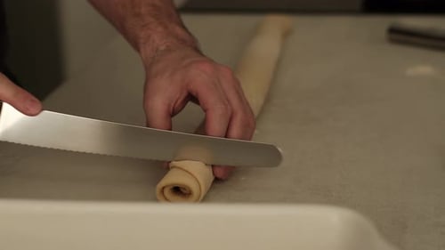 Slicing Rolled Dough with Serrated Knife for Baking