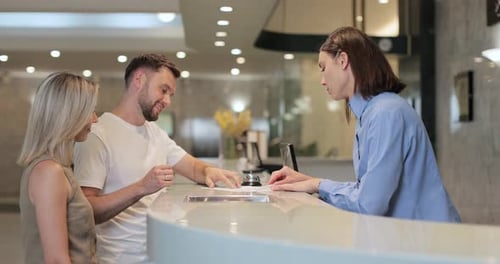 Young Couple Checking in at Modern Hotel Reception