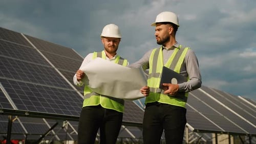 Two Male Engineers Discussing Solar Panel Project Plans