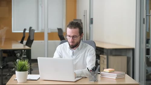 Professional Working on His Laptop in a Modern Office