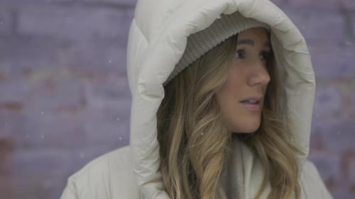 Une femme semble découragée alors qu'elle est debout dans le froid