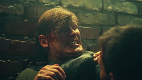 Injured Man in Intense Confrontation against Brick Wall