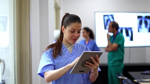 Smiling Woman Doctor Using Tablet in Hospital Room