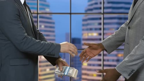 Businessmen with Money Shaking Hands