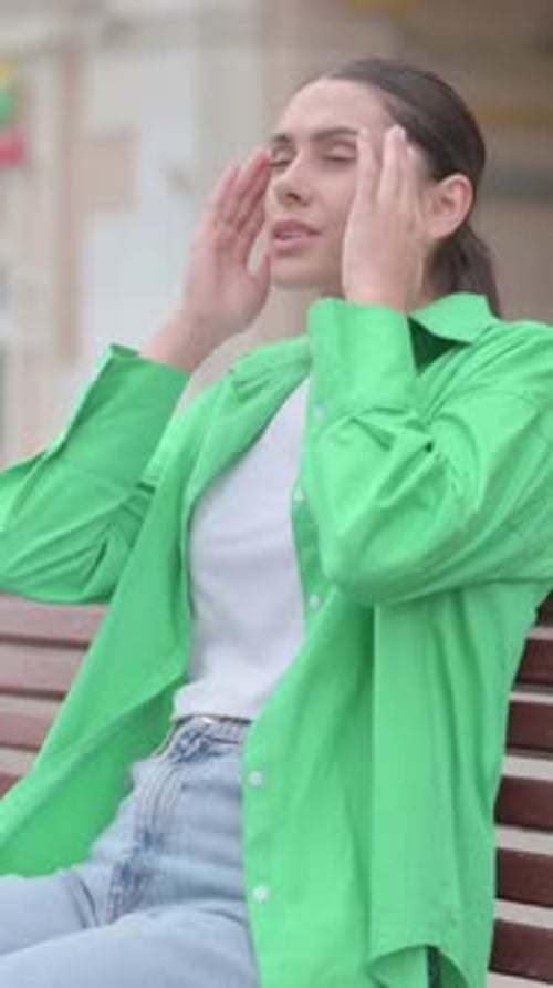 Woman Sitting on Bench with Headache