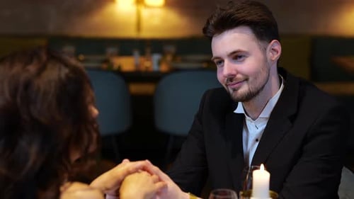 Romantic Man Listening His Girlfriend While Holding Her Hands Having Date in the Restaurant