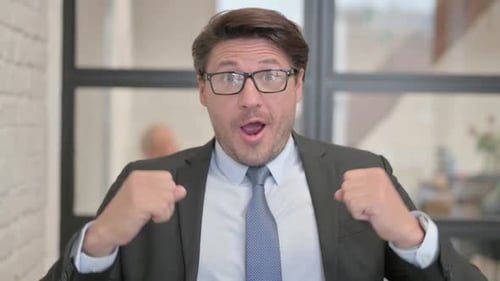 Portrait of Businessman Celebrating Success in Office