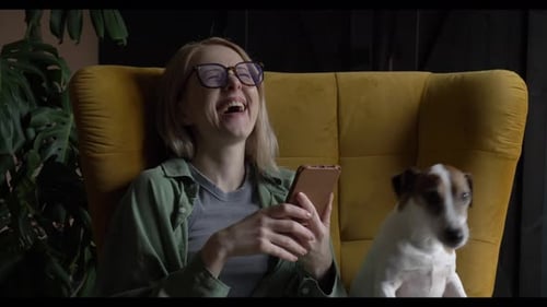 Woman Using Phone with Dog in Chair