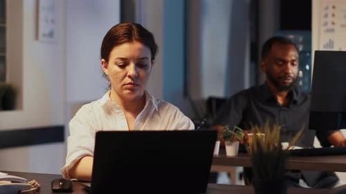 Portrait of Female Employee Using Laptop to Plan Startup Report