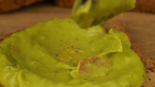 Spreading Fresh Avocado on Toast for a Meal