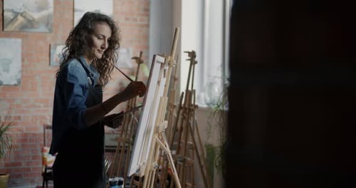 Young Woman Artist Wearing Apron Painting Picture Enjoying Creative Activity in Workshop