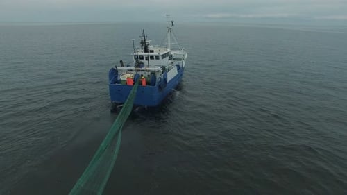 Fishing Boat Sails on the Ocean Pulling Net