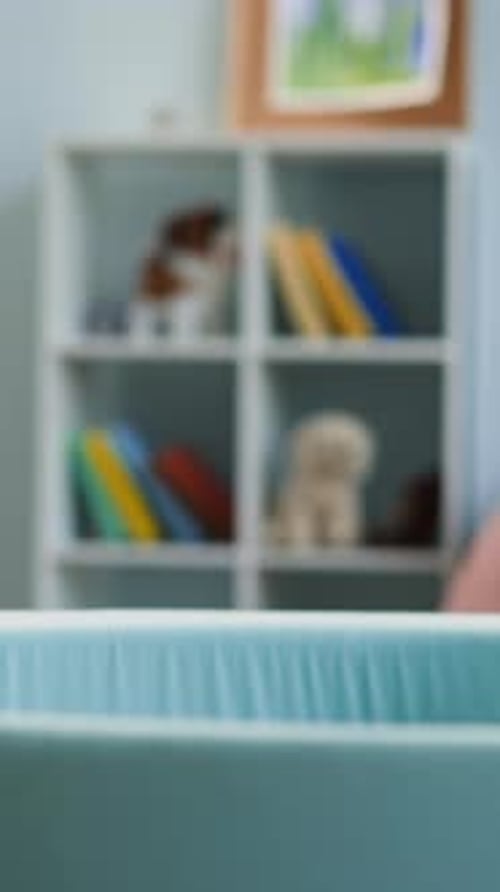 Menina pré-escolar se esconde na piscina seca jogando bolas coloridas