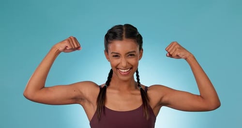 Young Woman Flexing Strong Muscles and Smiling
